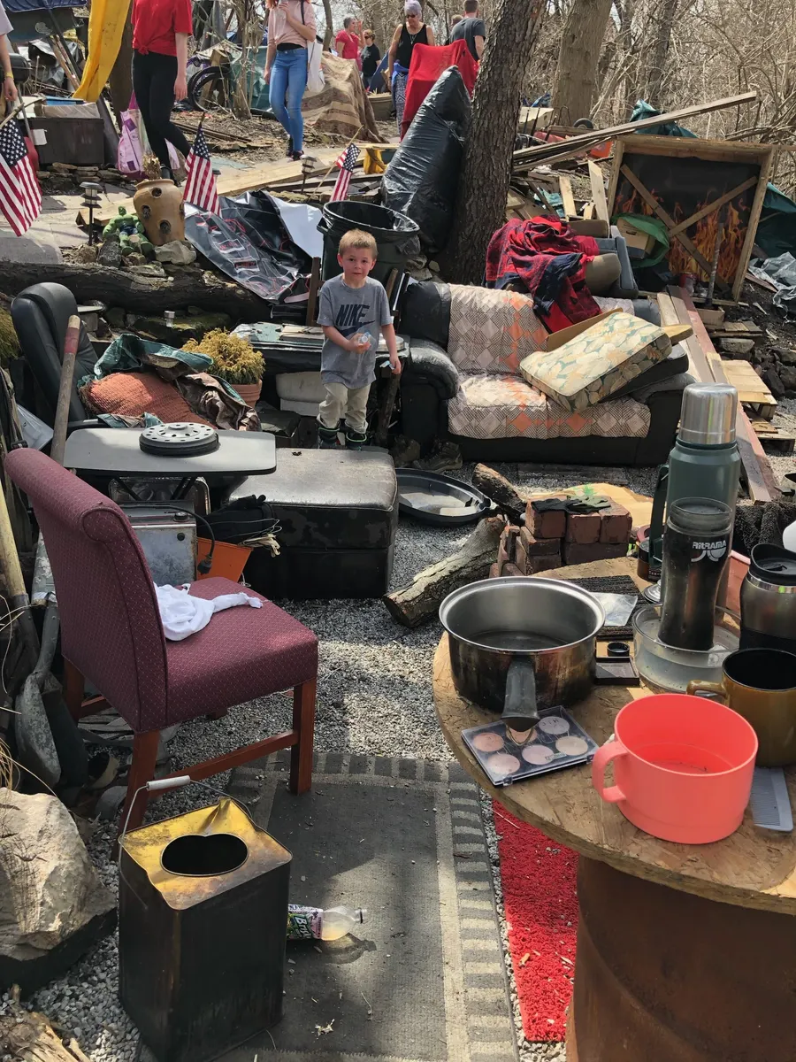 Camp scene with chairs and gear at a homeless encampment