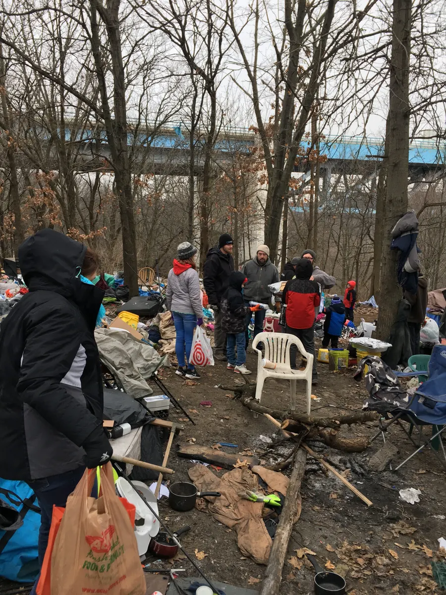 Volunteers serving at a homeless camp in the woods