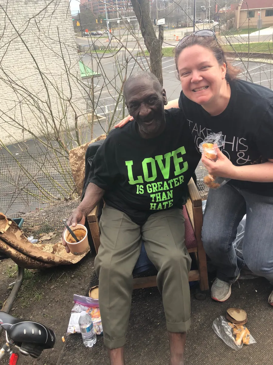 Two volunteers, one wearing a black LOVE t-shirt