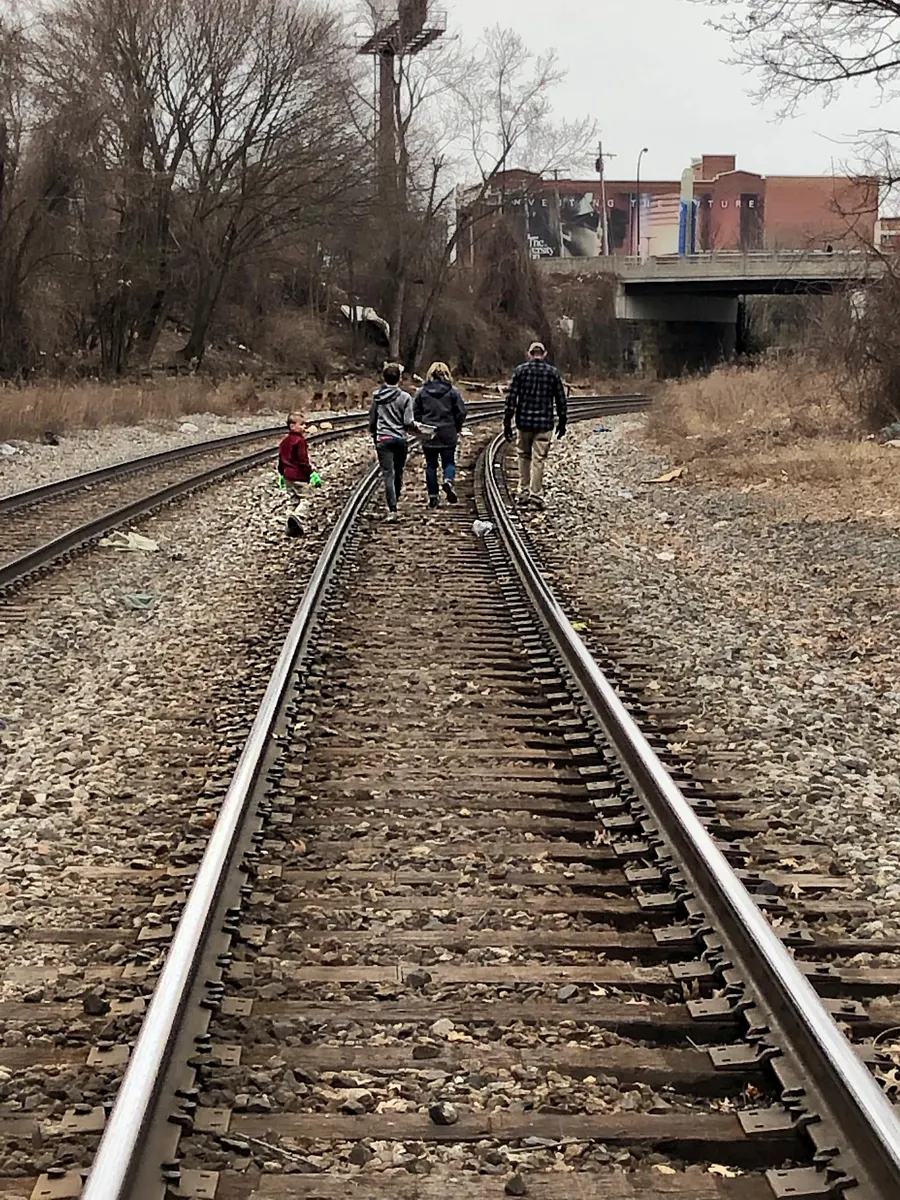 Volunteers walking along railroad tracks